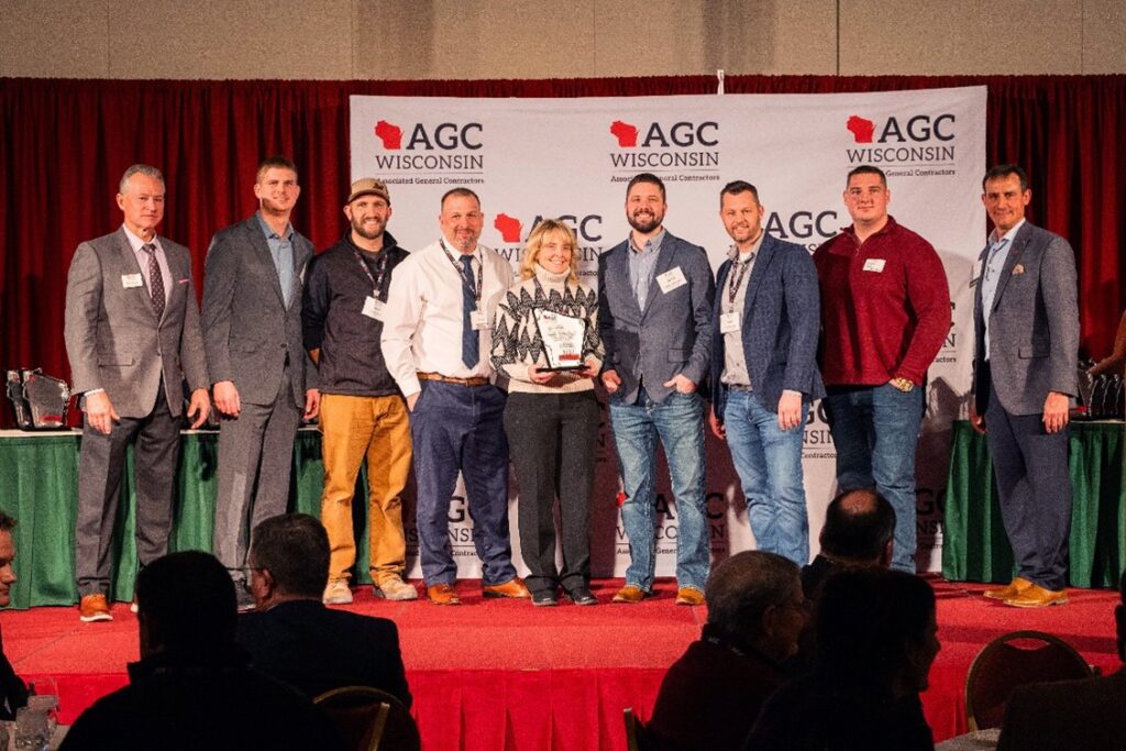 Team members from Faith Technologies Incorporated (FTI) and Mortenson accepting the 2024 BUILD Wisconsin award from Associated General Contractors (AGC) of Wisconsin. Pictured left to right: Bob Barker, AGC of Wisconsin; Nicholas Beck, FTI; David Hennes, Mortenson; Aaron Andreshak, FTI; Sheri McQuality, Mortenson; Derek Underdahl, FTI; Derek Berkley, FTI; Grant Allen, Mortenson; Brian Hornung, AGC of Wisconsin.